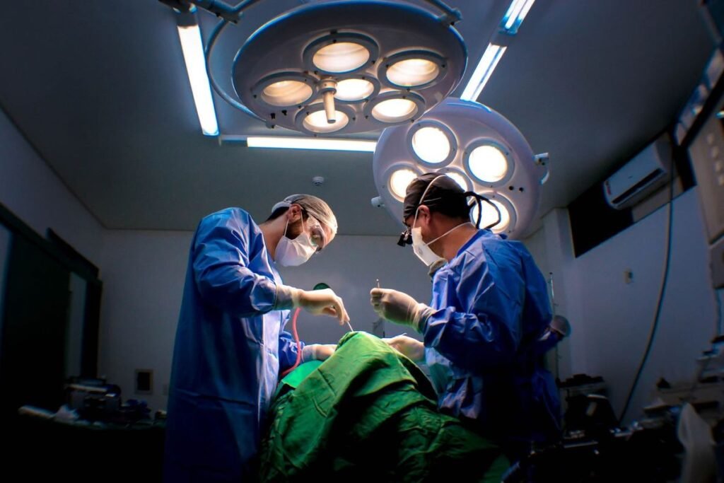Chirurgiens en bleu opèrent un patient sous des lumières opératoires