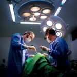 Chirurgiens en bleu opèrent un patient sous des lumières opératoires