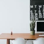 Bureau avec écran Apple, chaises blanches, cactus, calendrier février 2017