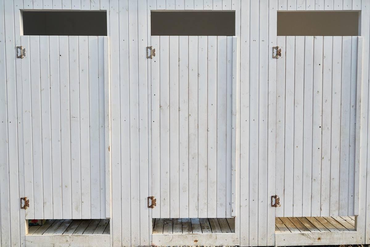 Trois portes de garage métalliques blanches montrant des traces de rouille et d'humidité en bord de mer Trois portes de garage métalliques blanches montrant des traces de rouille et d'humidité en bord de mer